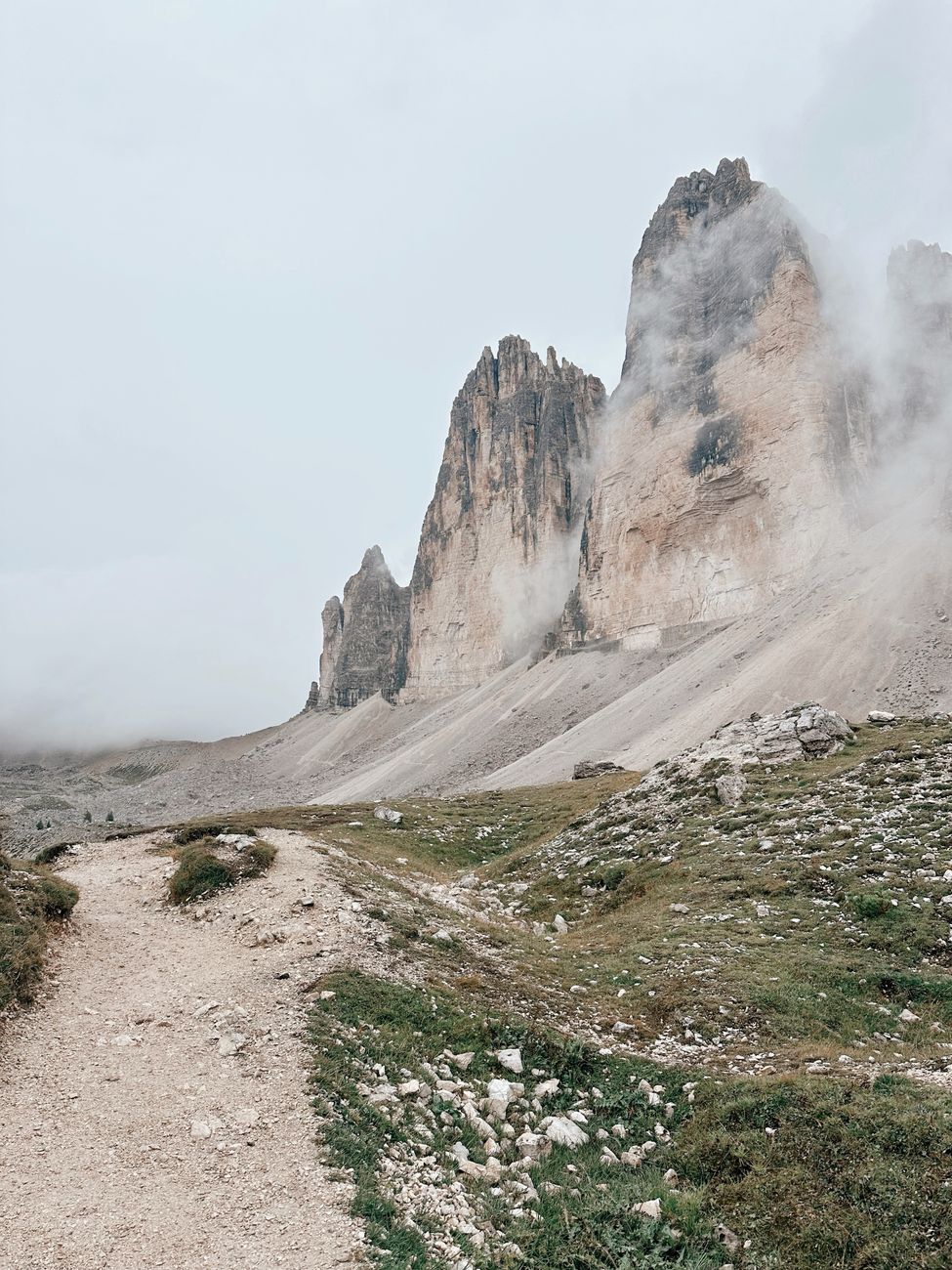 The towering limestone spires of Tre Cime di Lavaredo in morning mist